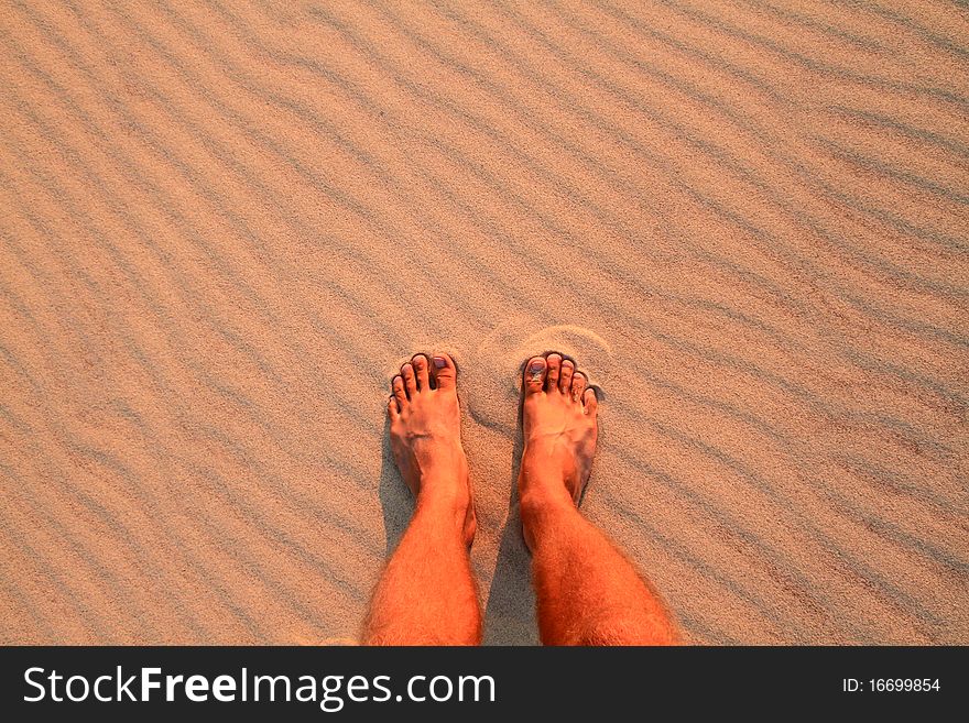 Feet on beach in sand ripples