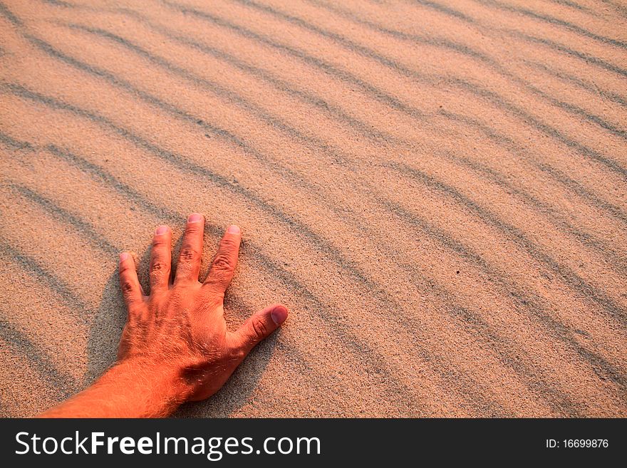 Hand feeling warm sand in sunset. Hand feeling warm sand in sunset