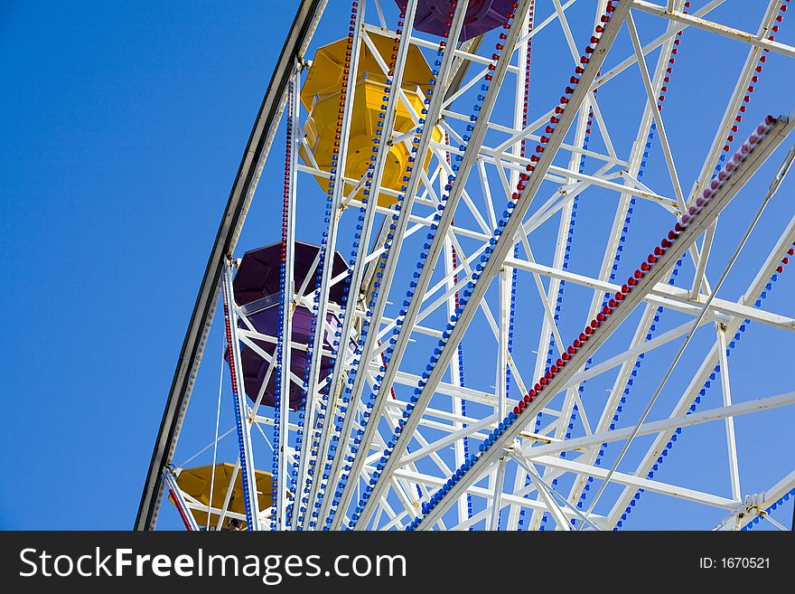 Shot of a ferris wheel with a bright blue sky.