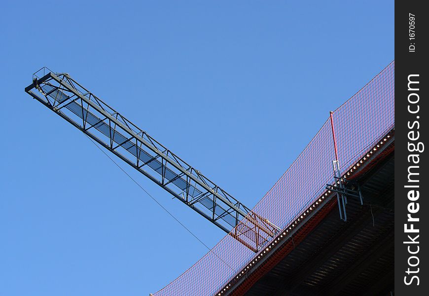 Abstract view of a crane with its arm towering over a building site. Abstract view of a crane with its arm towering over a building site