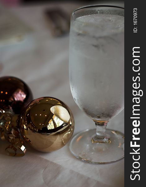 Place setting with glass and christmas ornaments on table. Place setting with glass and christmas ornaments on table