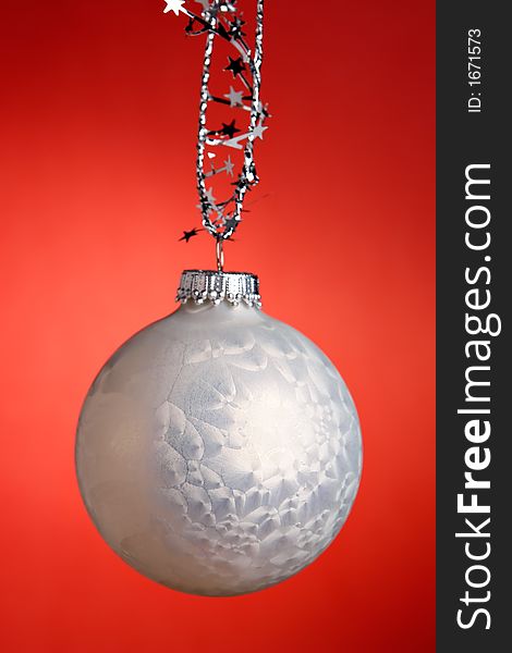 A single white christmas ornament on red. A single white christmas ornament on red