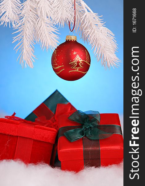 Christmas gifts and red ornament on white tree