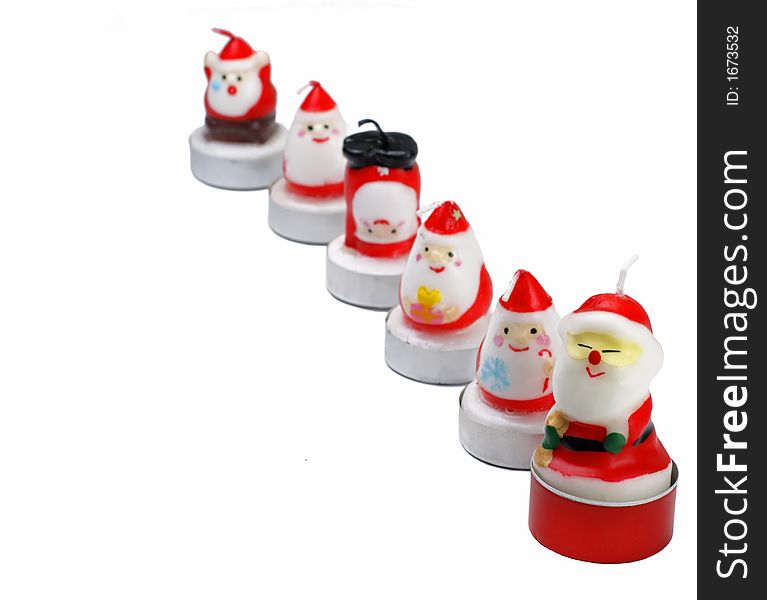 Funny Christmas candles in a row over white background, selective focus.