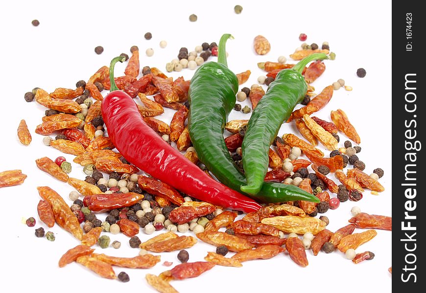 Green, red pepper and ground pepper on white background