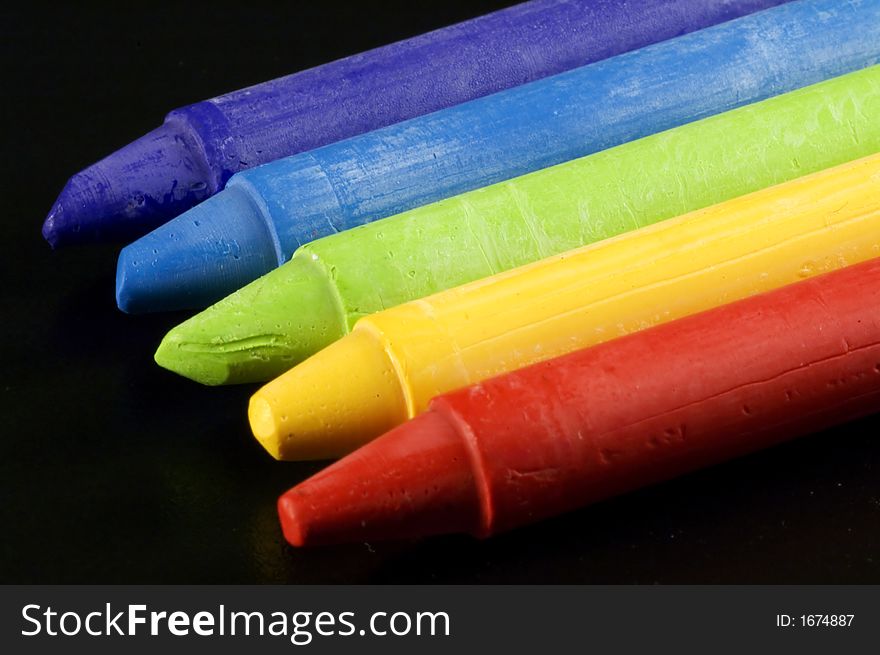 Some colorful wax colors on a black background. Some colorful wax colors on a black background