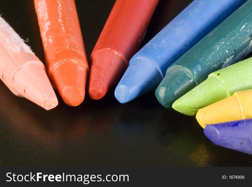Some colorful wax colors on a black background. Some colorful wax colors on a black background