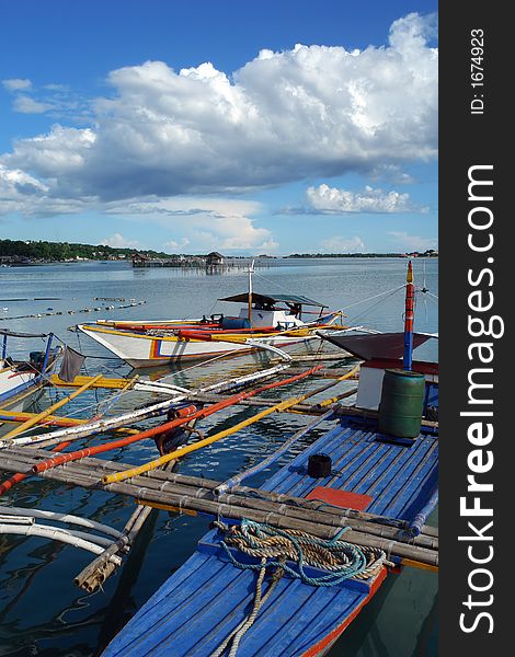 Southeast Asian colorful fishermenï¿½s boats under a majestic tropical sky and cloudscape. Southeast Asian colorful fishermenï¿½s boats under a majestic tropical sky and cloudscape.