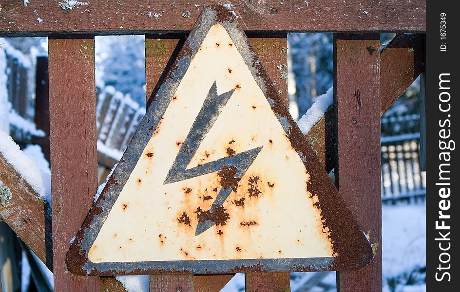 Sign dangerously on a wooden fence