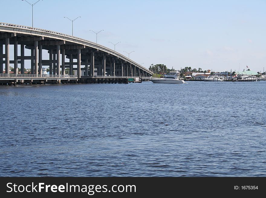 Bridge over river with boat crossing underneath.