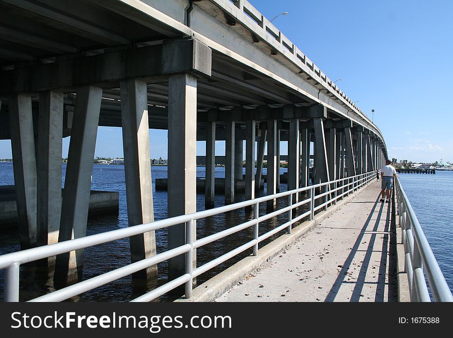 Man walking along fishing bridge. Man walking along fishing bridge