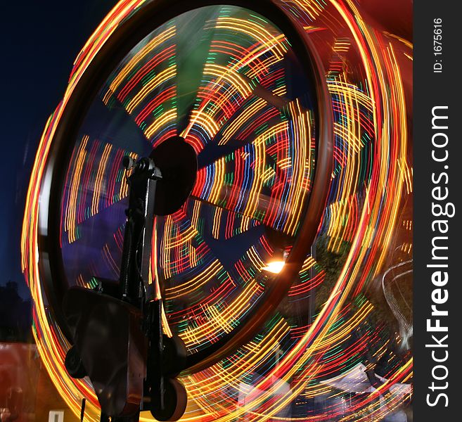 A ferris wheel that appears to be moving at top speed. A ferris wheel that appears to be moving at top speed