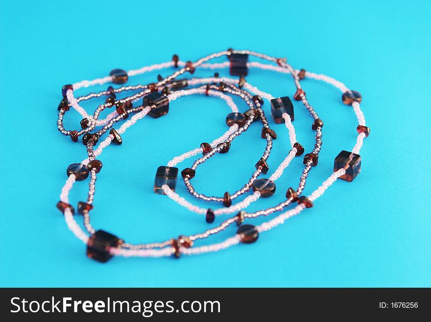Beaded necklace on a blue background - shallow DOP