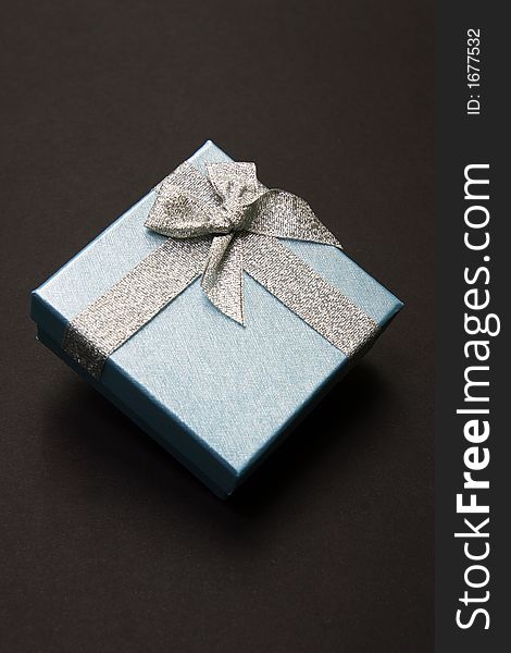 Gift Box with Silver Ribbon against Black background