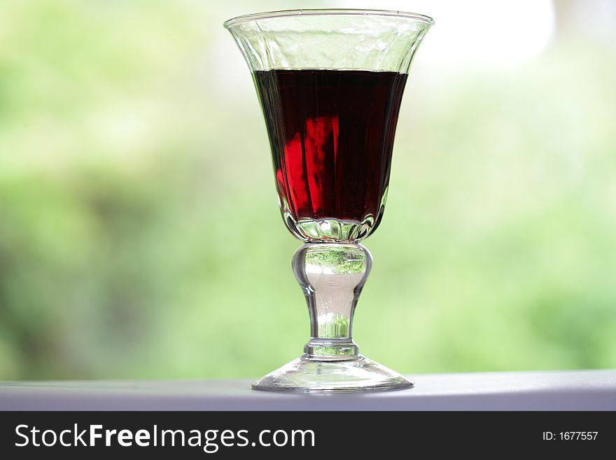 Red wine glass with green background