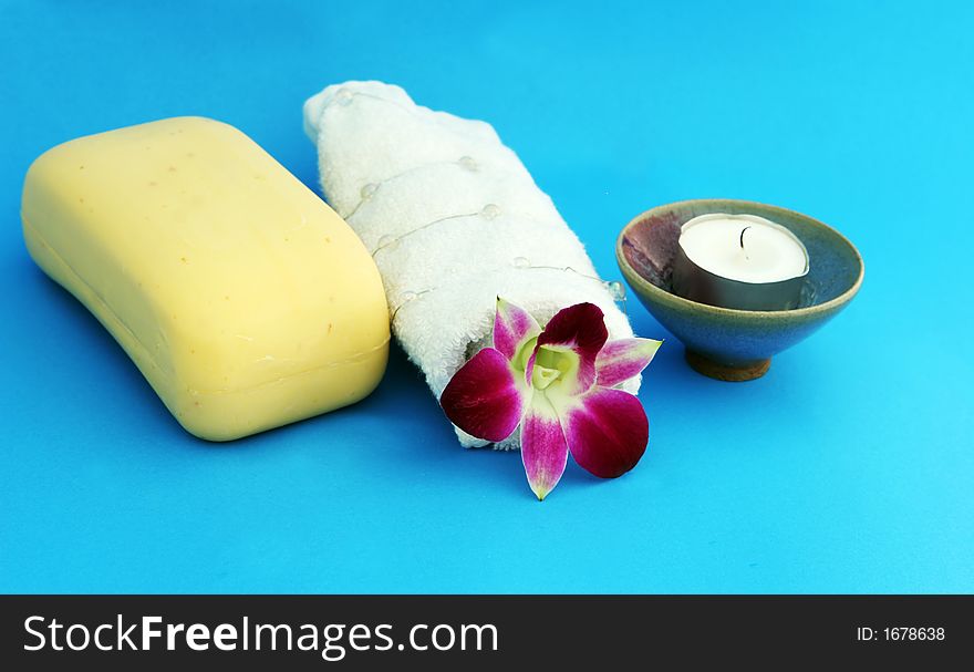 Spa products - soap, candle and white towel with orchid