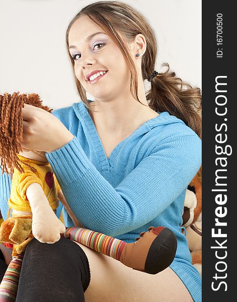 Young woman having fun playing with dolls