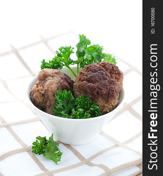 Two meat balls in white bowl with parsley. Two meat balls in white bowl with parsley