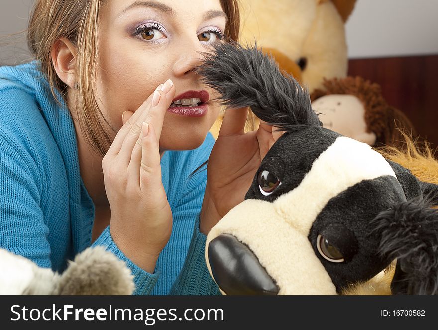 Young woman having fun playing with dolls