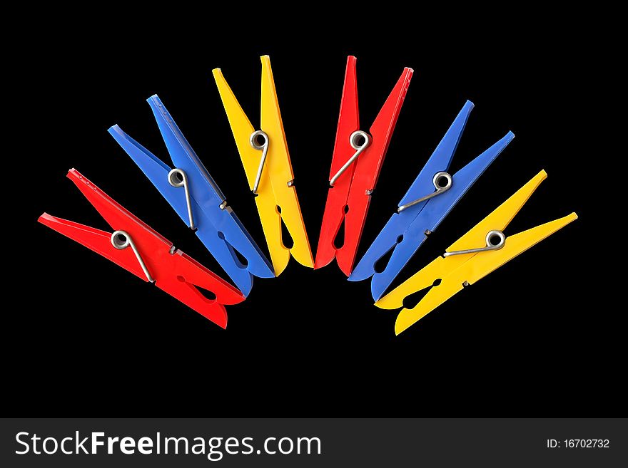 Set of motley clothespins isolated on black background with clipping path