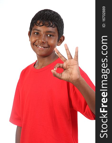 Teenager boy expressing OK signal using hand sign while smile posing in studio against white background. Teenager boy expressing OK signal using hand sign while smile posing in studio against white background