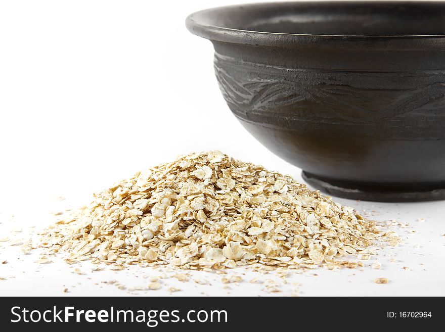 Oats and ceramic bowl over white. Oats and ceramic bowl over white