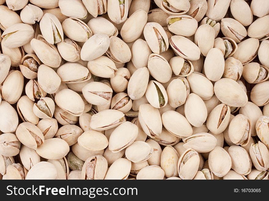 Nuts Pistachios are scattered as a background on a table.