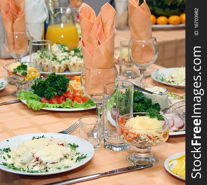 Table covered at restaurant with salads in the foreground