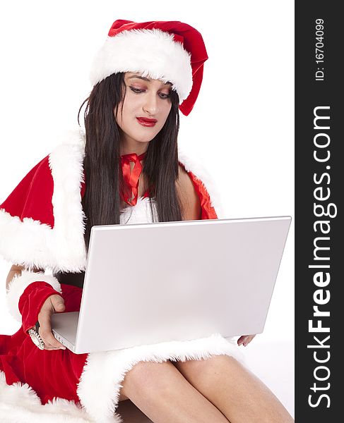 A dark haired Mrs Santa with a laptop. A dark haired Mrs Santa with a laptop