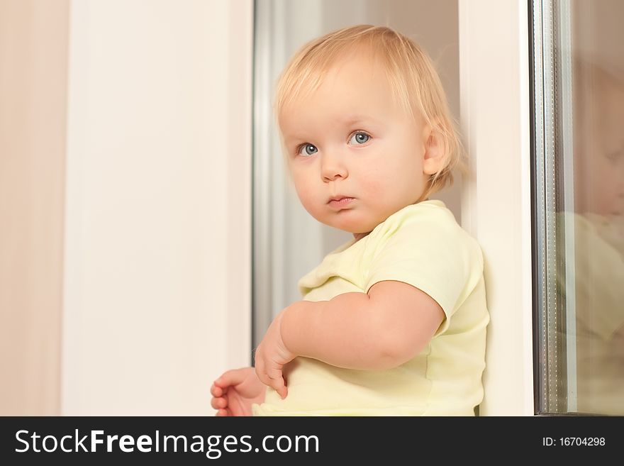 Adorable toddler girl sitting on the window sill. Adorable toddler girl sitting on the window sill