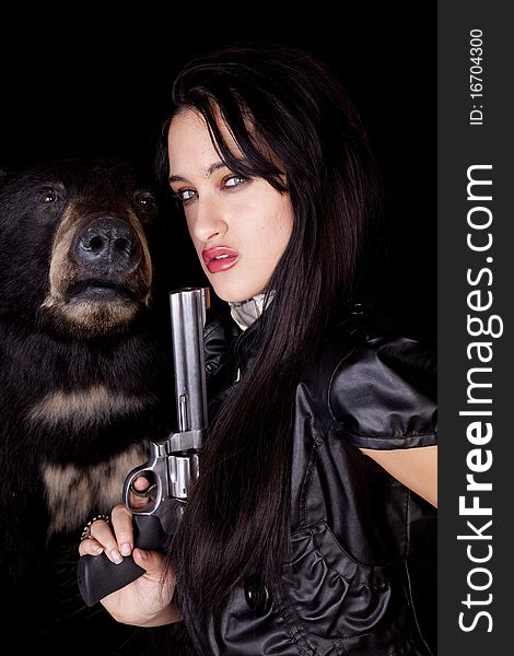 A woman is holding a gun by a black bear. A woman is holding a gun by a black bear.