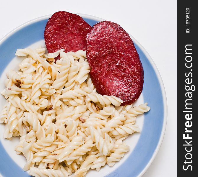 Fried sausage with a garnish in a plate on a white background. Fried sausage with a garnish in a plate on a white background.