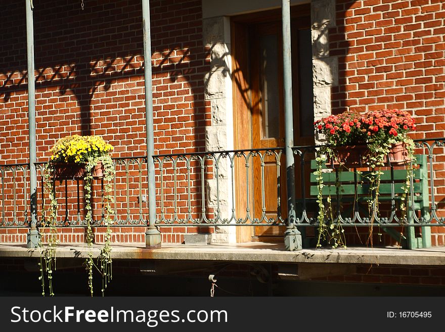 Photo of balcony with flowers and bricks and shadows. Photo of balcony with flowers and bricks and shadows.
