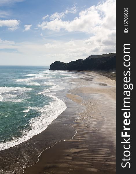 People and surfers walking on huge Beach, piha, new zealand. People and surfers walking on huge Beach, piha, new zealand