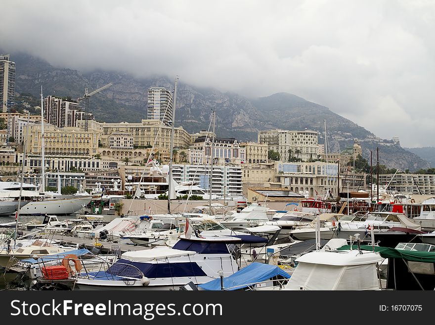 Monaco harbor seen with dozens of boats and the Casino building on the hill at right. Monaco harbor seen with dozens of boats and the Casino building on the hill at right.