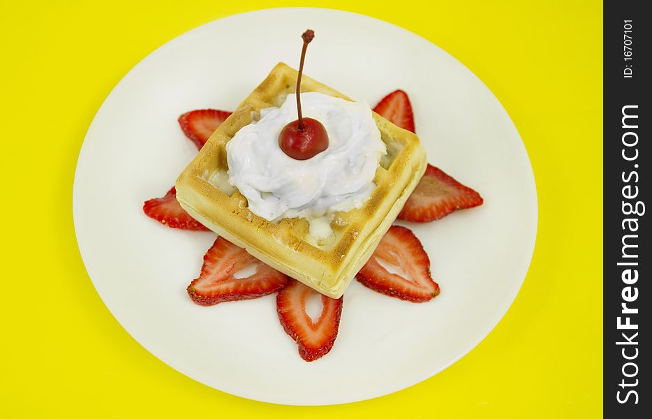 Belgian waffle with strawberry bas, whipped cream and a cherry on top. studio lights and 100mm macro lens. Yellow bright paper Background. Belgian waffle with strawberry bas, whipped cream and a cherry on top. studio lights and 100mm macro lens. Yellow bright paper Background.