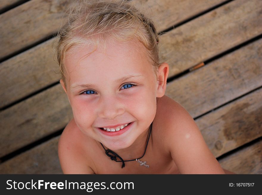 Beautiful girl's portrait against wooden background in summertime