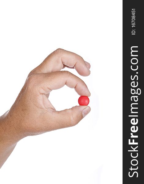 Hand is holding a red pill isolated on white background