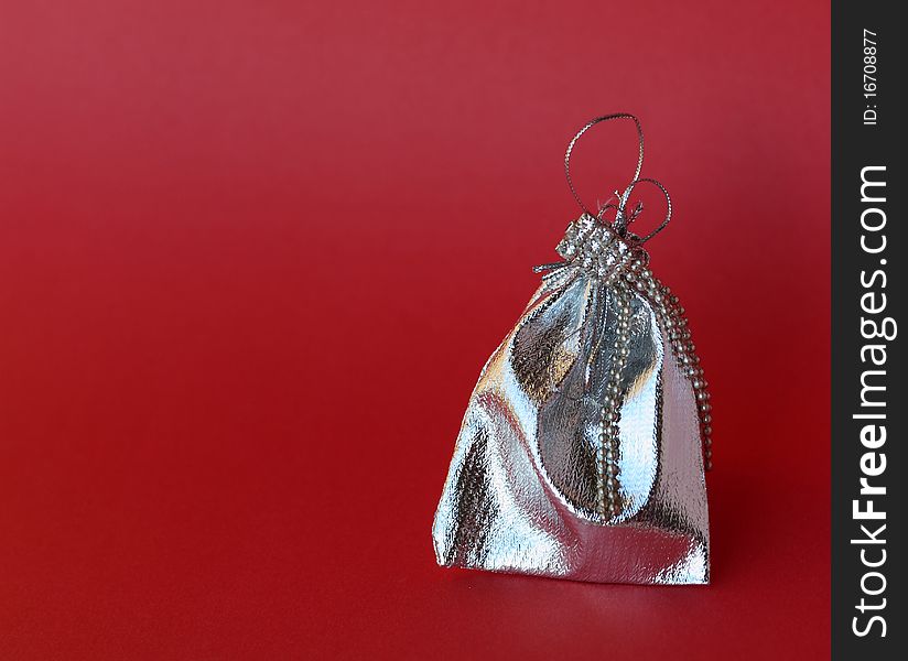 Packaging made from silver fabric for jewelry on a red background. Packaging made from silver fabric for jewelry on a red background