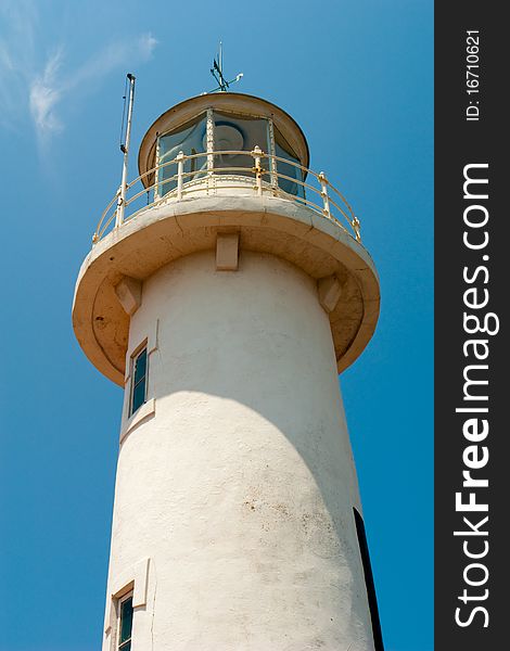 Marine white stone lighthouse in the sun against the blue sky. Marine white stone lighthouse in the sun against the blue sky