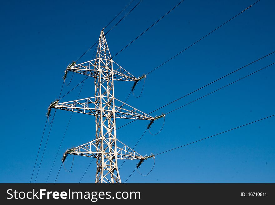 High voltage pylon against blue sky. High voltage pylon against blue sky