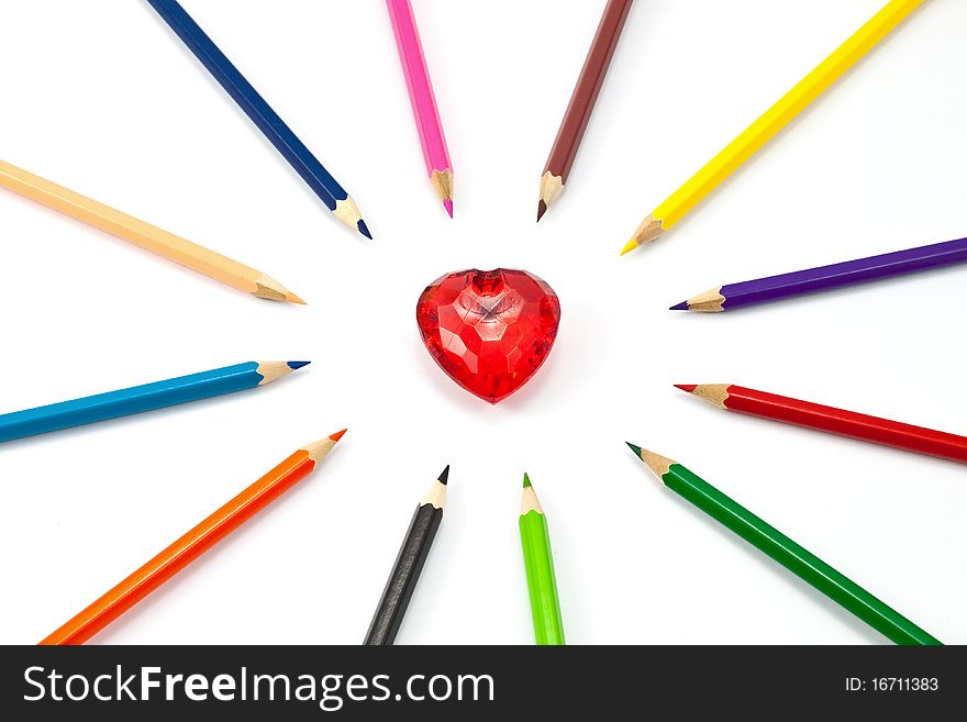 Red crystal heart surrounded with color pencil. Red crystal heart surrounded with color pencil