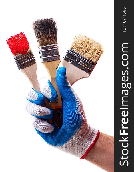 Hand in a white glove holding brushes for paints. Hand in a white glove holding brushes for paints