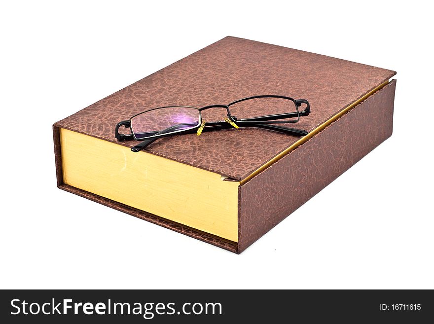 Old brown book and single len eyeglass isolated on a white background. Old brown book and single len eyeglass isolated on a white background