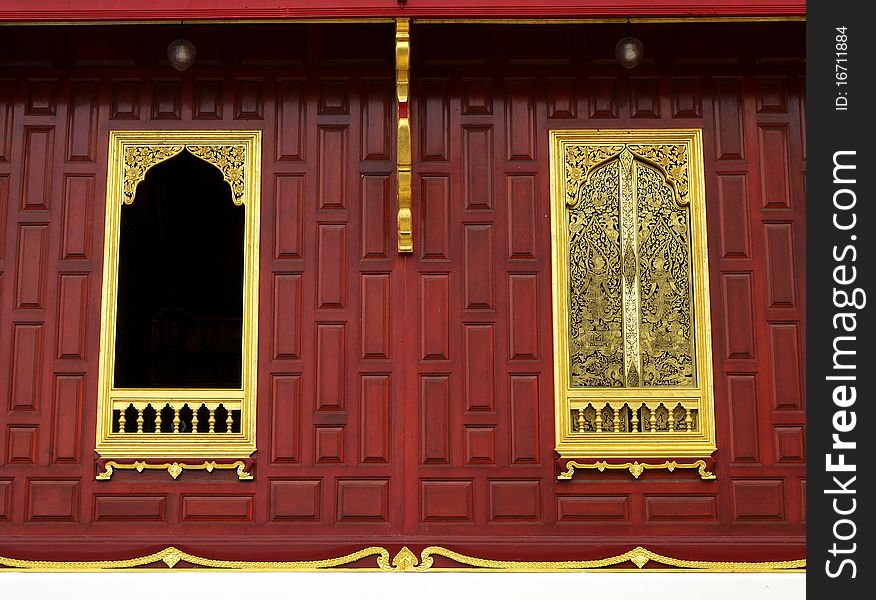 Gold window on wood wall in temple traditional Thai style architecture