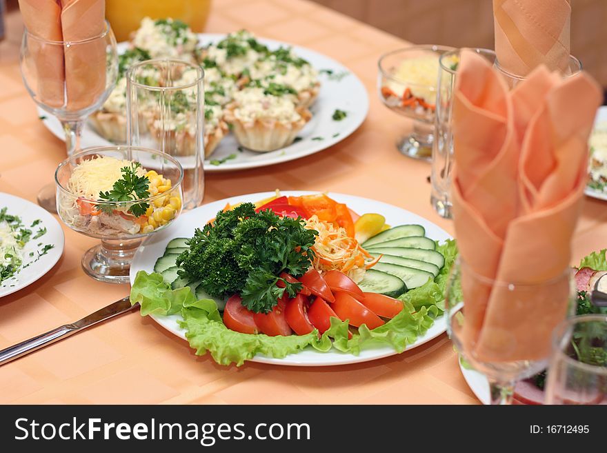 Table covered at restaurant with salad in the foreground