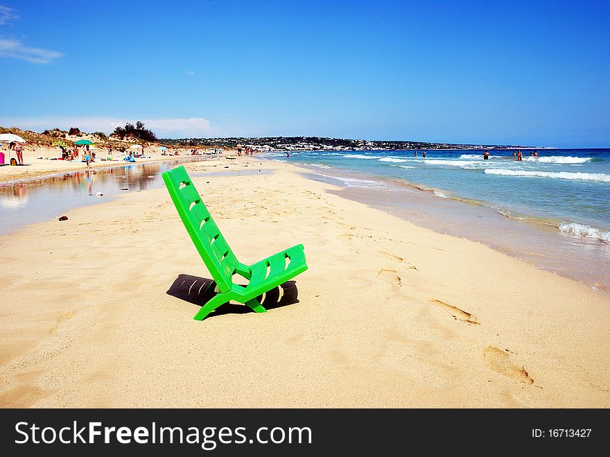 Green deckchair on the sea shore in summer bright day