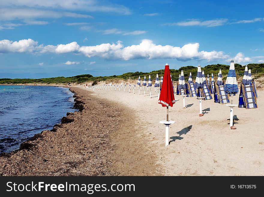 Red beach-umbrella in deserted sandy beach in summer. Red beach-umbrella in deserted sandy beach in summer