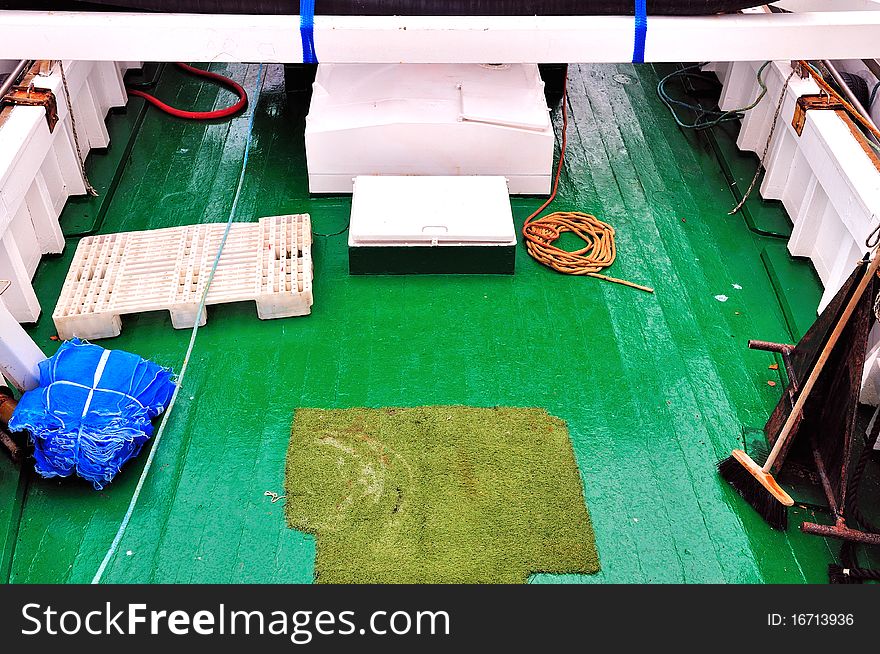 Green deck of a fishing boat moored in the harbor