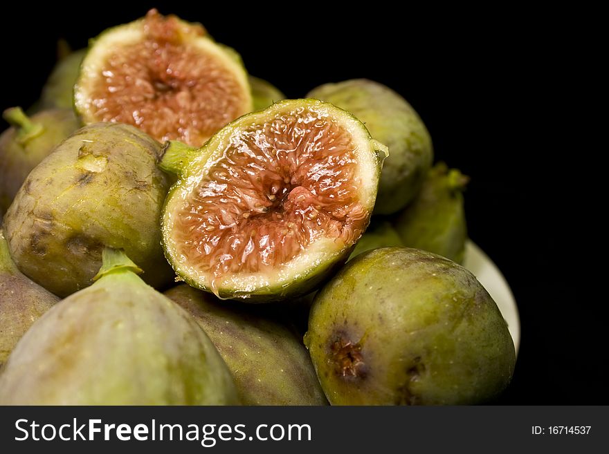 Half fig on a plate of green figs